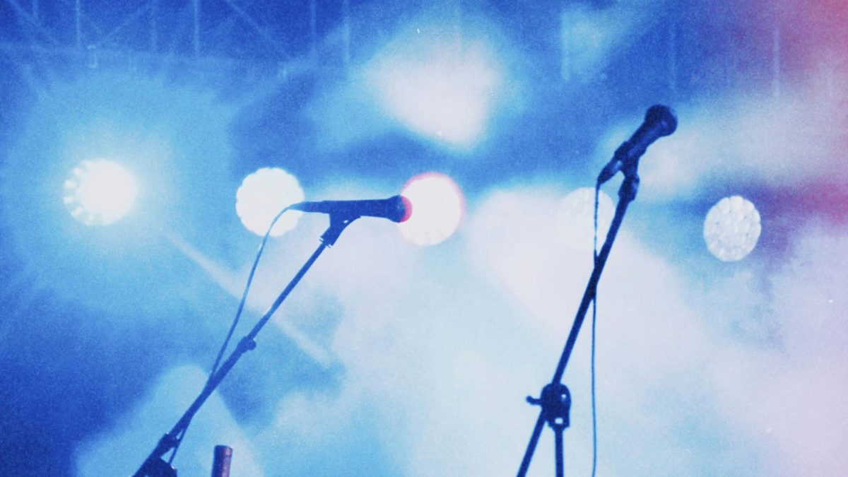 Vista de escenario con dos micrófonos durante la celebración de un evento