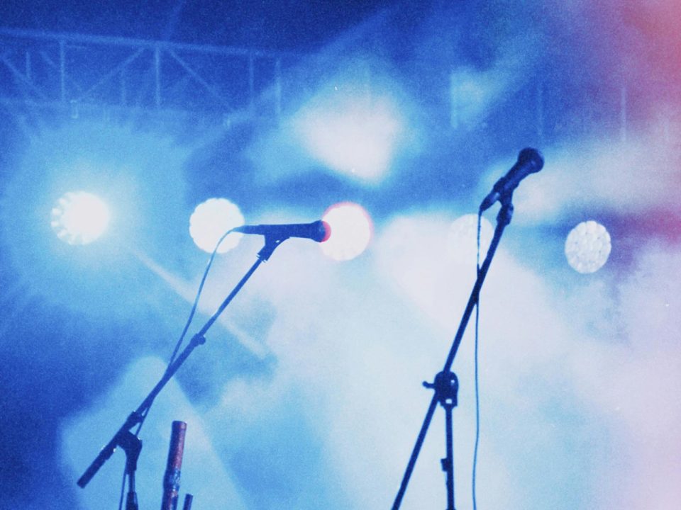 Vista de escenario con dos micrófonos durante la celebración de un evento