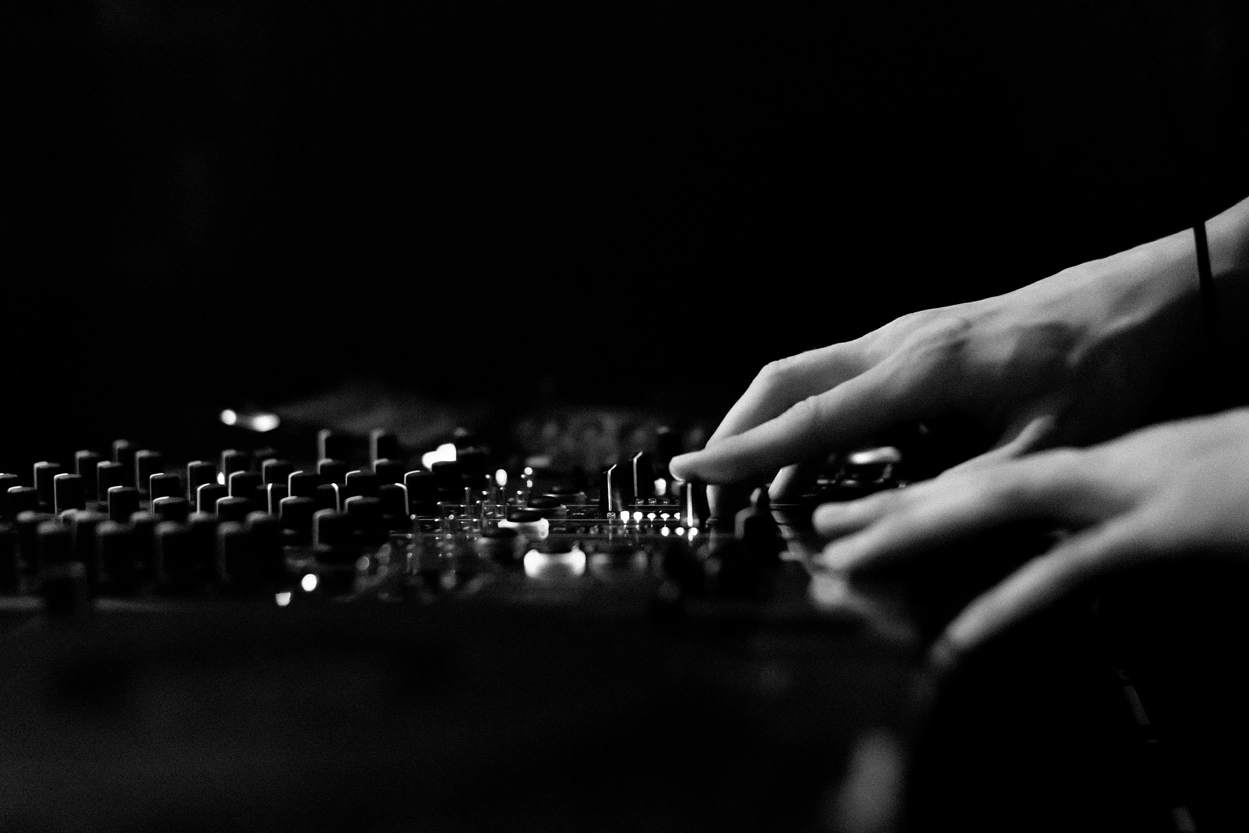 Primer plano de una mesa de sonido con las manos de un técnico