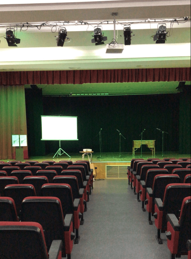 Salón de actos vacío con escenario al fondo