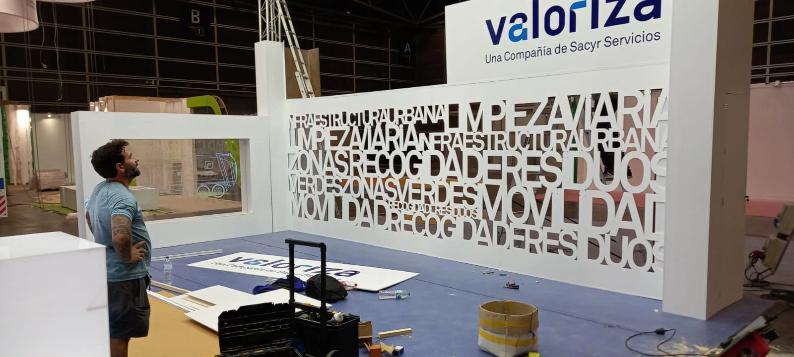 Preparación del stand de valoriza con un operario de A-System trabajando en la instalación