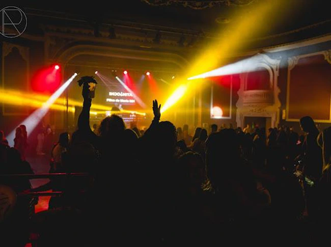 Vista de salón de un teatro con público bailando con instalación discomóvil