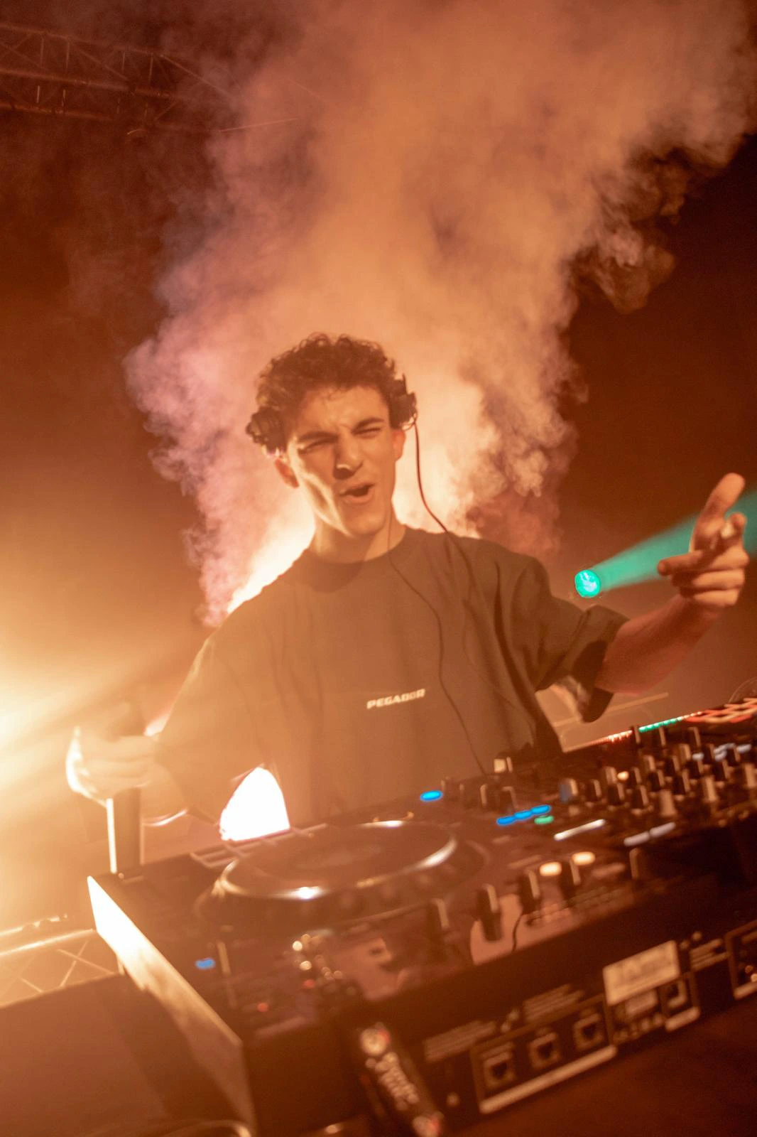 DJ frente a mesa de mezclas en la celebración de un evento con efectos de humo e iluminación