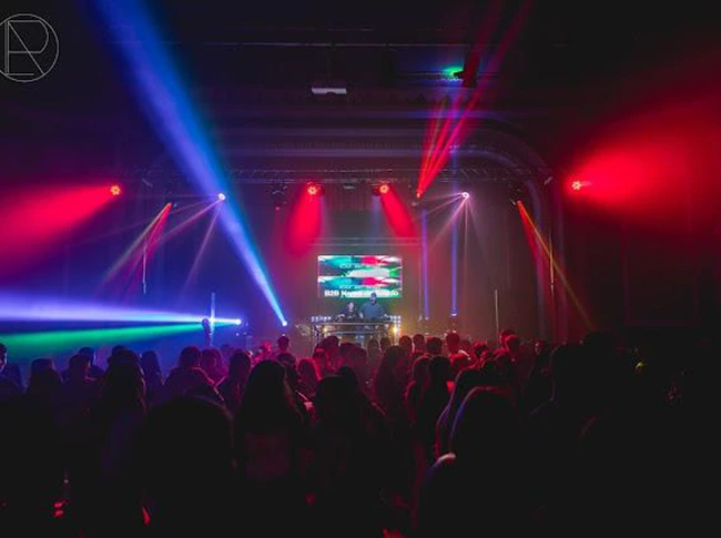 Vista de salón de un teatro con público bailando con instalación discomóvil
