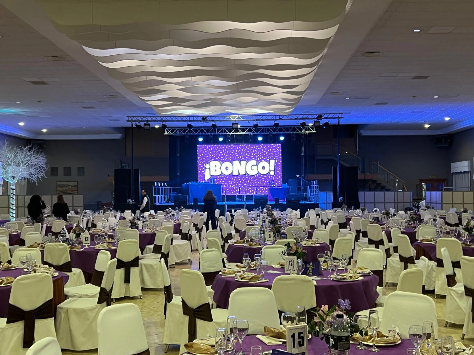 Gran salón con mobiliario de mesas y sillas dispuestos para evento