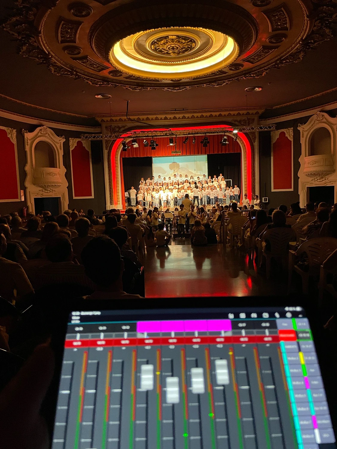 Mesa de sonido con escenario al fondo en sala de teatro