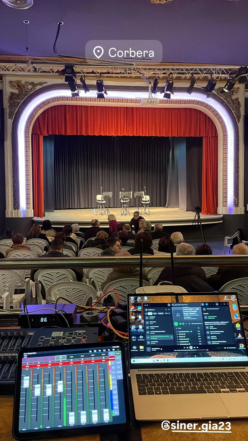 Mesa de sonido con escenario al fondo en sala de teatro