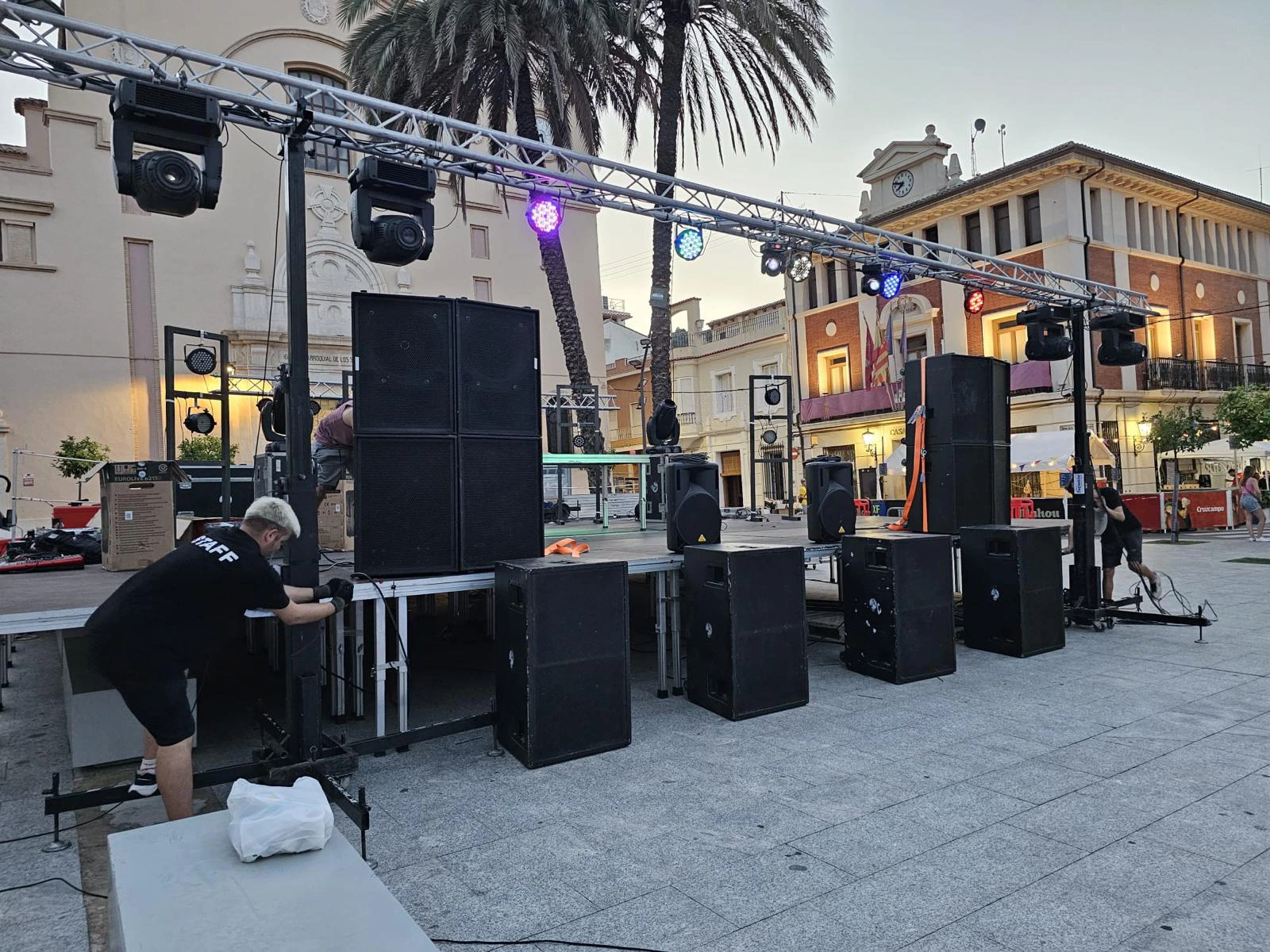 Preparación de escenario por operarios de A-System con elementos de iluminación y sonido
