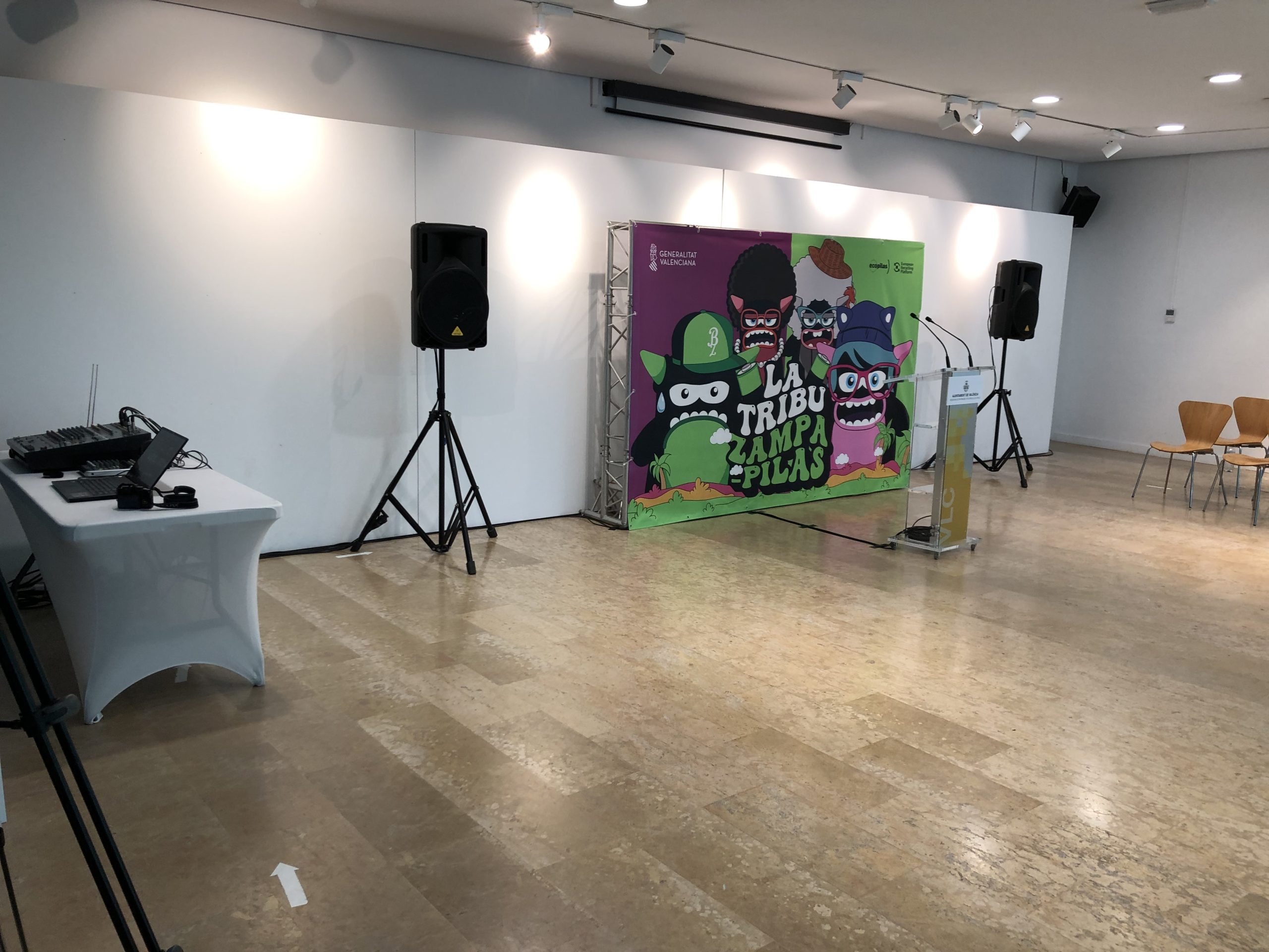 Evento corporativo en salón interior con iluminación, sonido y elementos gráficos