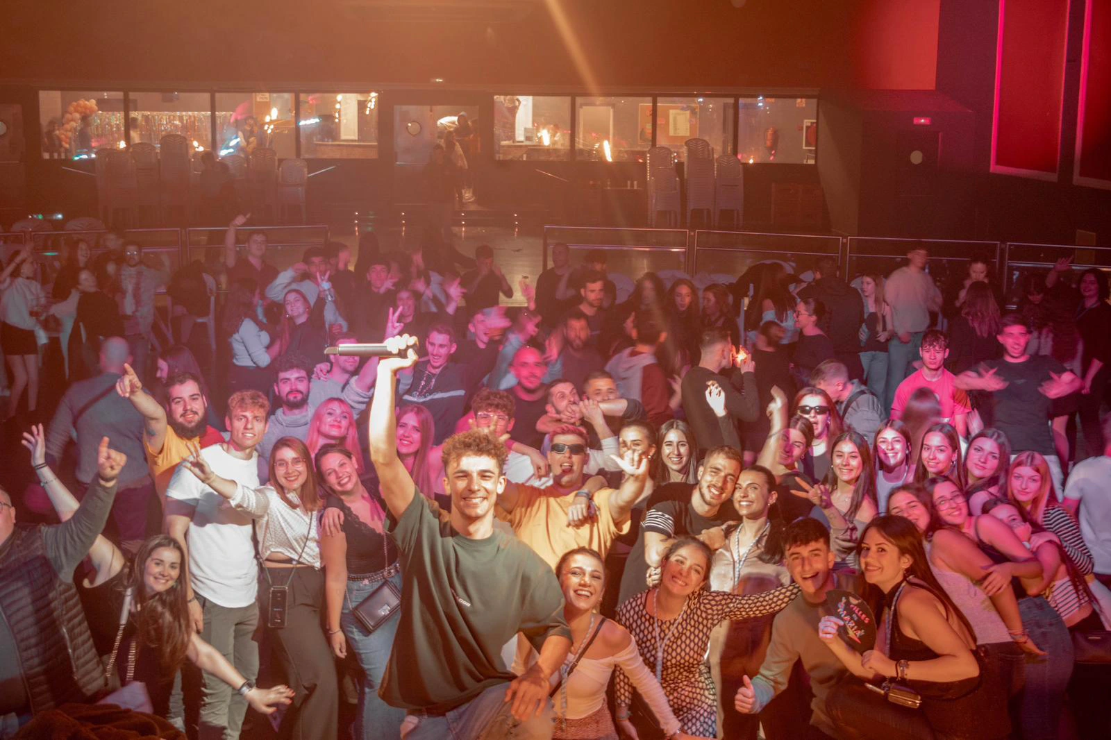 Asistentes a la celebración de un evento junto con el DJ