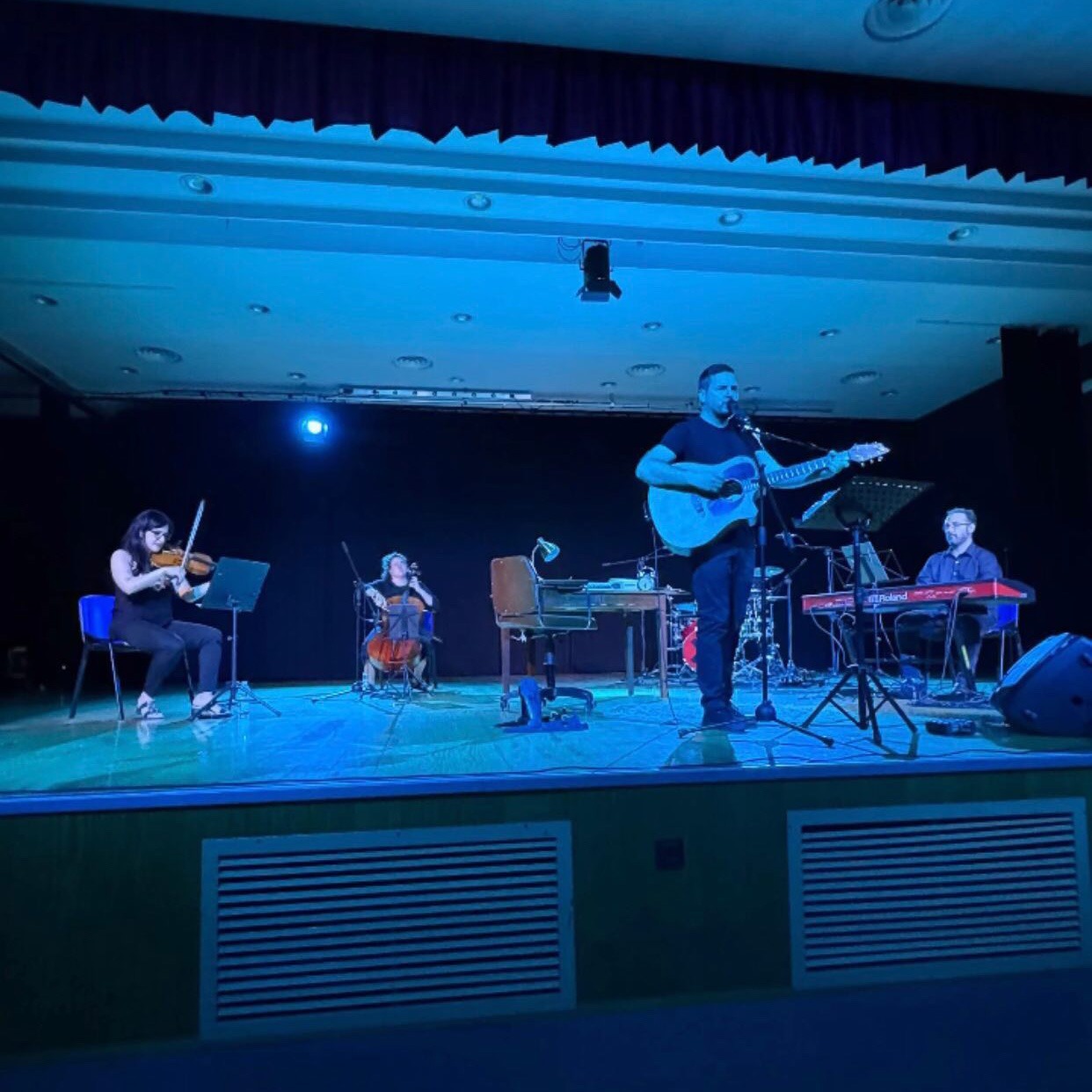 Escenario con músicos tocando distintos instrumentos